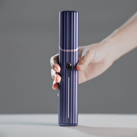 Hand holding the FORSCI. CAP Renewal Wand skincare device.